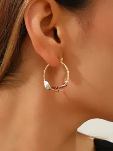Close-up detailopname van de stijlvolle driekleurige bedeloorring gedragen aan het oor.