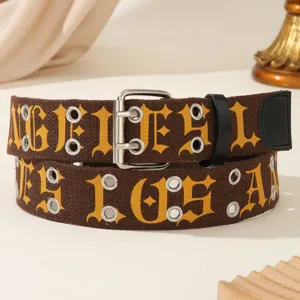 Detailed view of brown canvas belt with yellow gothic letters and double metal eyelets.