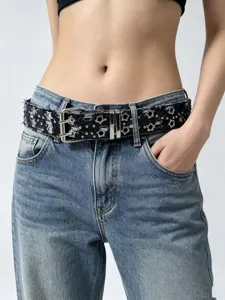 Punk style black star-studded double pin buckle belt detail, stylish denim jeans accessory.