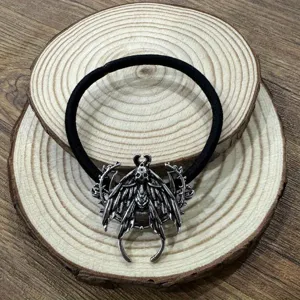 Nahaufnahme des gotischen Vintage-Totenkopf-Motten-Haargummis mit schwarzem Gummiband.