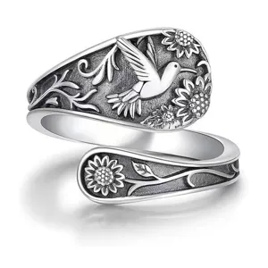 Detailed close-up of vintage silver adjustable ring featuring hummingbird and sunflower relief design.