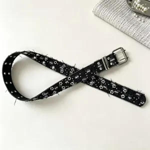 Detailed view of the punk style star patterned double buckle belt with metal grommets.