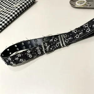 Detail view of black punk style belt featuring star eyelets, metal double pin buckle and texture.