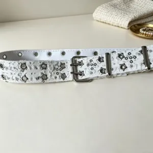 Detailed view of white punk style double-pin grommet belt featuring silver star studs.