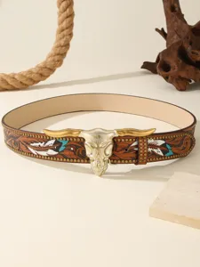 Detailed view of western style leather belt with bull skull buckle and carved feather details.