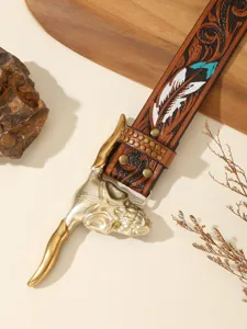 Close up of vintage western leather belt with bull skull buckle and carved floral details.