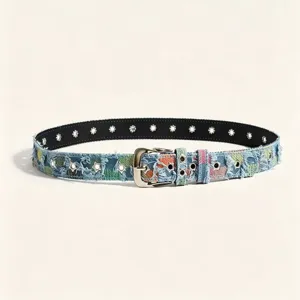 Gros plan détaillé de la ceinture en denim patchwork élégante avec œillets et boucle.