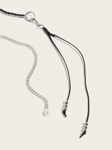 Detailed view of fashionable metal chain and leather waist belt accessory with pearls.