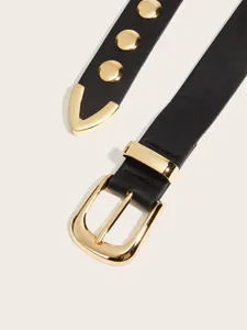 Primo piano di cintura in pelle nera con elegante fibbia dorata e borchie metalliche.
