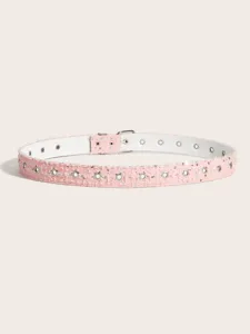 Dettaglio cintura in denim rosa con occhielli a stella, accessorio moda punk in metallo.