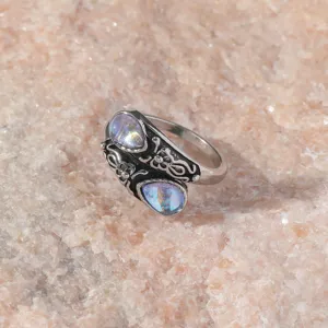 Vintage style silver ring detail shot, ornate relief moonstone jewelry close up view.
