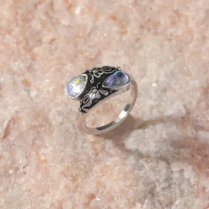Vintage silver ring with double teardrop stones and bohemian floral relief details.