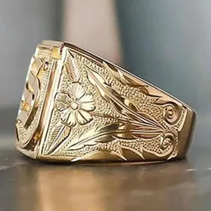 Detailed close-up view of vintage gold-colored engraved ring with floral botanical patterns.