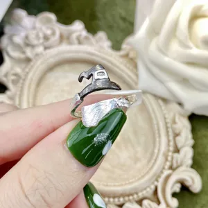 Primo piano dettagliato del design dell'anello regolabile cappello da strega e scopa.