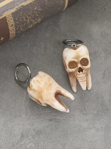 Gothic Halloween skull tooth earrings detail close-up, punk style dark horror jewelry item.