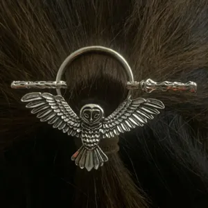 Vista dettagliata del fermaglio per capelli gufo e bacchetta d'argento, accessorio gotico.