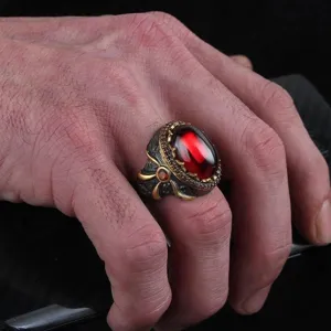 Vintage men's ring with gun black and gold two-tone plating, featuring a large red central stone.