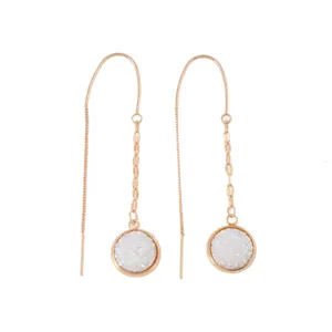 Detailed close-up of long rose gold threader earrings featuring sparkling white druzy pendants.