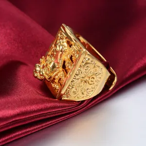 Detailopname van de gouden drakenring met ingewikkelde reliëfstructuur op rode satijn.