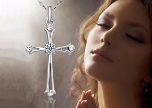 Detail of silver cross pendant necklace featuring sparkling central cubic zirconia and delicate chain.