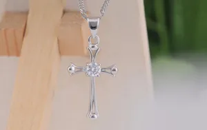 Close-up of elegant silver cross pendant necklace sparkling crystal zirconia stone fine chain