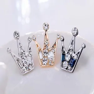 Dettaglio ravvicinato di spille a corona in strass scintillanti, elegante accessorio per abito.