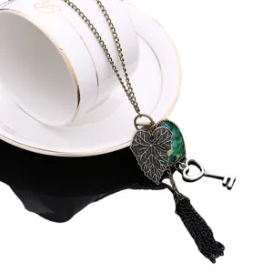 Collar largo de bronce vintage con pluma de pavo real corazón hoja llave y borla.
