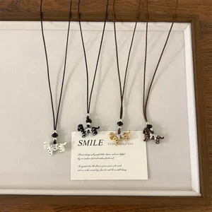 Detailed shot of cute spotted dog pendant necklaces in four colors with delicate bows.