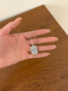 Stunning silver cross pendant necklace featuring sparkling diamond pavé and blue crystal.