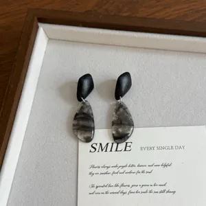Detail view of vintage wooden and marbled drop earrings, unique art design, chic daily accessory.