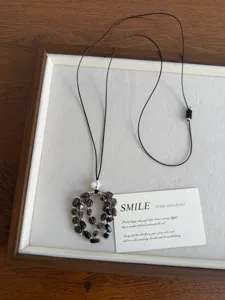 Retro natural stone grape beaded necklace with adjustable black cord and elegant design detail.