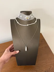 Vista dettagliata della collana a strati francese con choker floreale in rete e pendente.