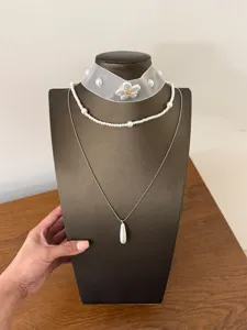 Vista dettagliata della collana di perle multistrato stile francese con choker e ciondolo.