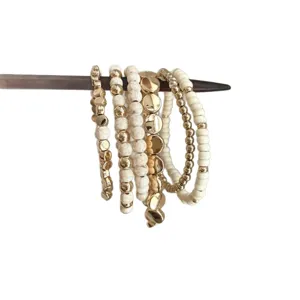 Bohemian multi-layer beaded bracelet detail, featuring white marbled and gold beads.