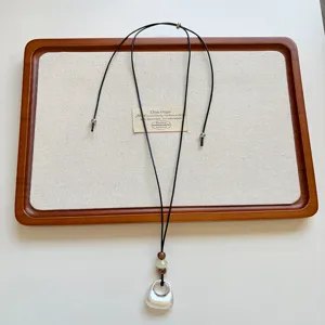 Scatto di dettaglio di una collana con ciondolo geometrico in argento stile nicchia coreana.