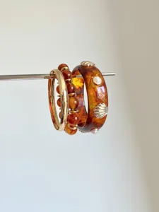 Detail shot of multi-layer stacked resin tortoise shell and bead bangles bracelet set.