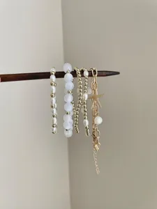 Detail shot of multi-layer stackable beaded bracelets featuring pearls and starfish pendant.