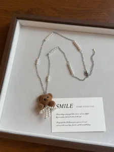 Brown flocked bear necklace detail view with pearl beading and stylish long sweater chain.
