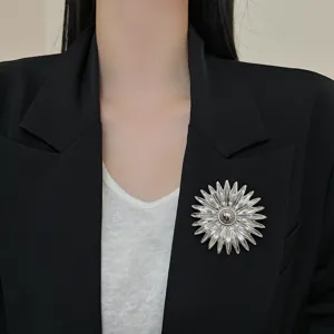 Detailed shot of a vintage metal sunflower brooch, exaggerated silver statement pin for women.