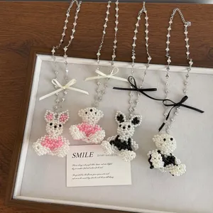 Detailed shot of cute beaded pearl bunny and bear necklaces with bows on tray display.