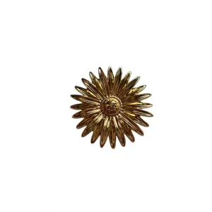 Detailed close-up of a vintage golden metal sunburst brooch, exquisite textured petals.