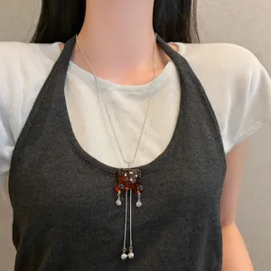 Collana lunga da maglione con ciondolo a forma di orso in resina e nappe eleganti.