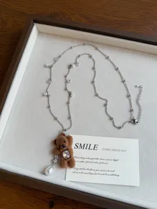 Detailed view of a cute plush bear pendant pearl beaded necklace, aesthetic jewelry piece.