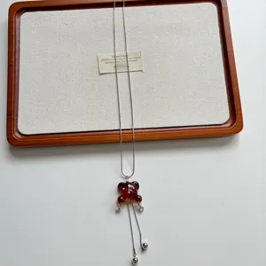 Primo piano della lunga collana con ciondolo a forma di orsetto ambrato trasparente.