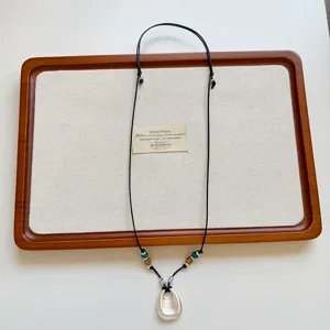 Dettaglio della collana con ciondolo geometrico argento dal design coreano con cordino.