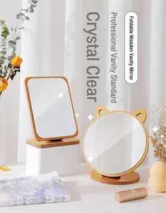 Close-up detail of stylish desktop makeup mirrors featuring natural wood frames and base