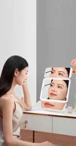 Primer plano de un espejo de maquillaje LED plegable portátil en un tocador