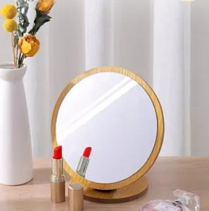 Detailed view of a circular wooden desktop mirror on a vanity table with lipsticks