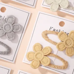 Détail rapproché de jolies barrettes marguerites brodées à la main sur présentoirs