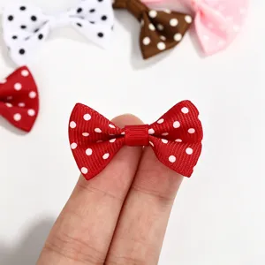 Close-up of a mini red polka dot grosgrain ribbon bow for DIY crafts and hair accessories